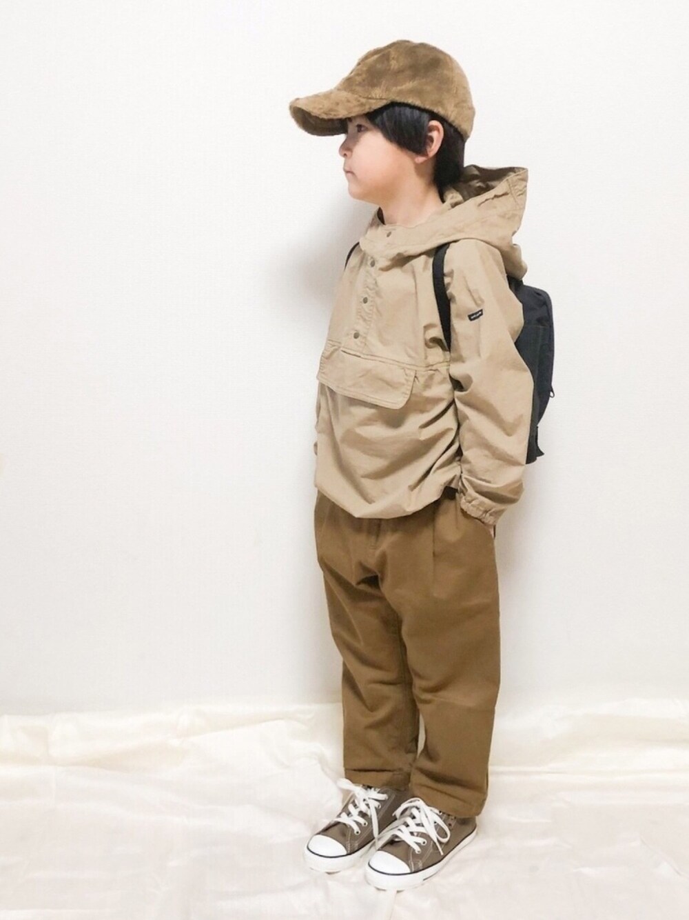 ベージュ系のその他アウター、ブラウン系のその他パンツ、ブラウン系のスニーカーを着用したキッズの冬コーディネートの1枚目の写真