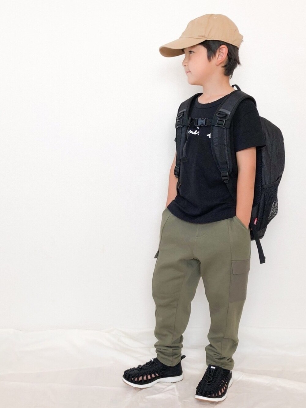 ブラック系のTシャツ/カットソー、グリーン系のカーゴパンツ、ブラック系のスニーカーを着用したキッズの秋コーディネートの1枚目の写真