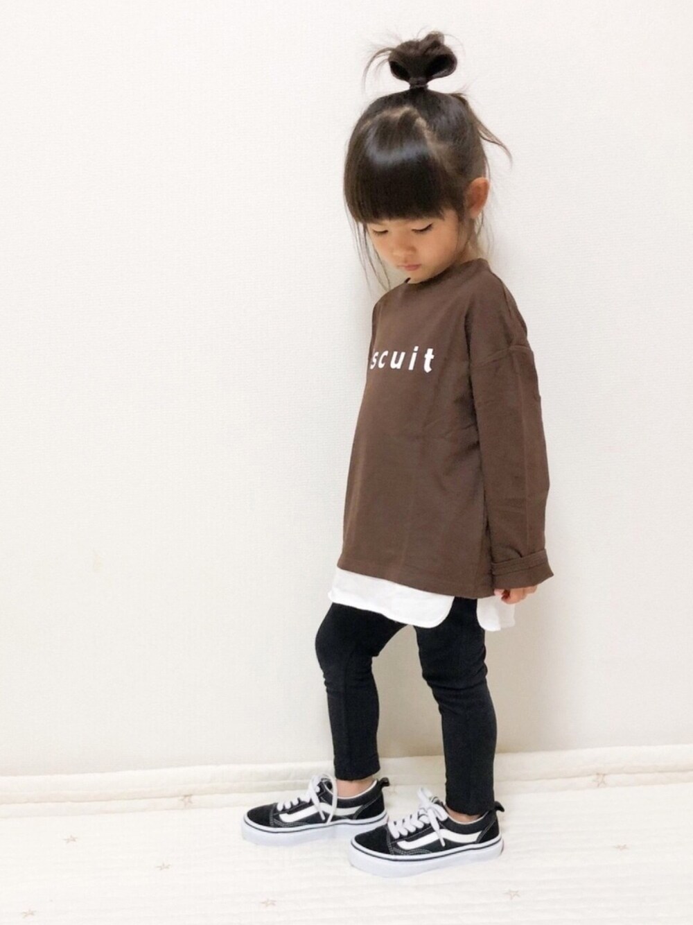 ベージュ系のTシャツ/カットソー、ブラック系のその他パンツ、ブラック系のスニーカーを着用したキッズの秋コーディネートの1枚目の写真