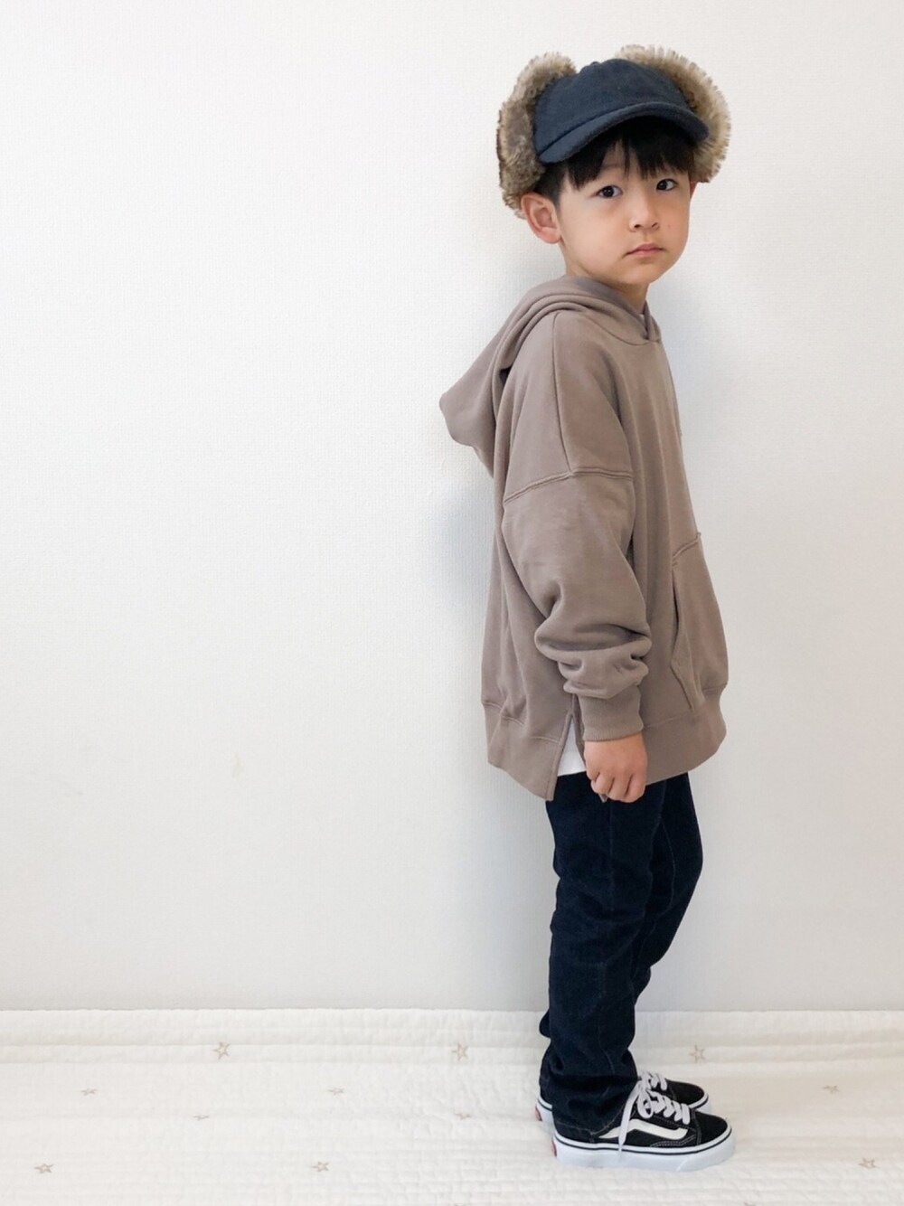 ベージュ系のパーカー、ブルー系のデニムパンツ、ホワイト系のTシャツ/カットソーを着用したキッズの冬コーディネートの1枚目の写真