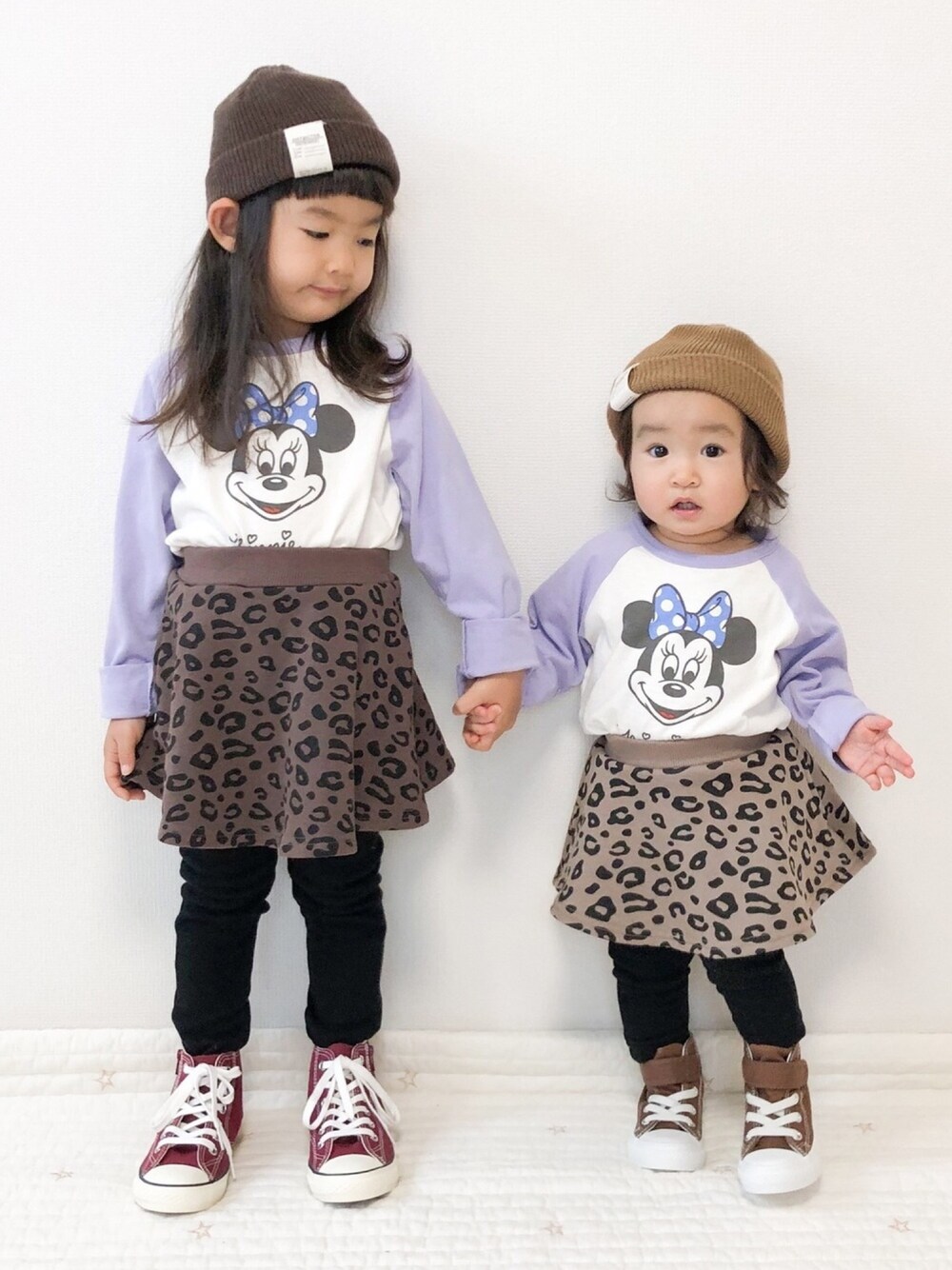 ブラウン系のスカート、ベージュ系のスカート、レッド系のスニーカーを着用したキッズの冬コーディネートの1枚目の写真