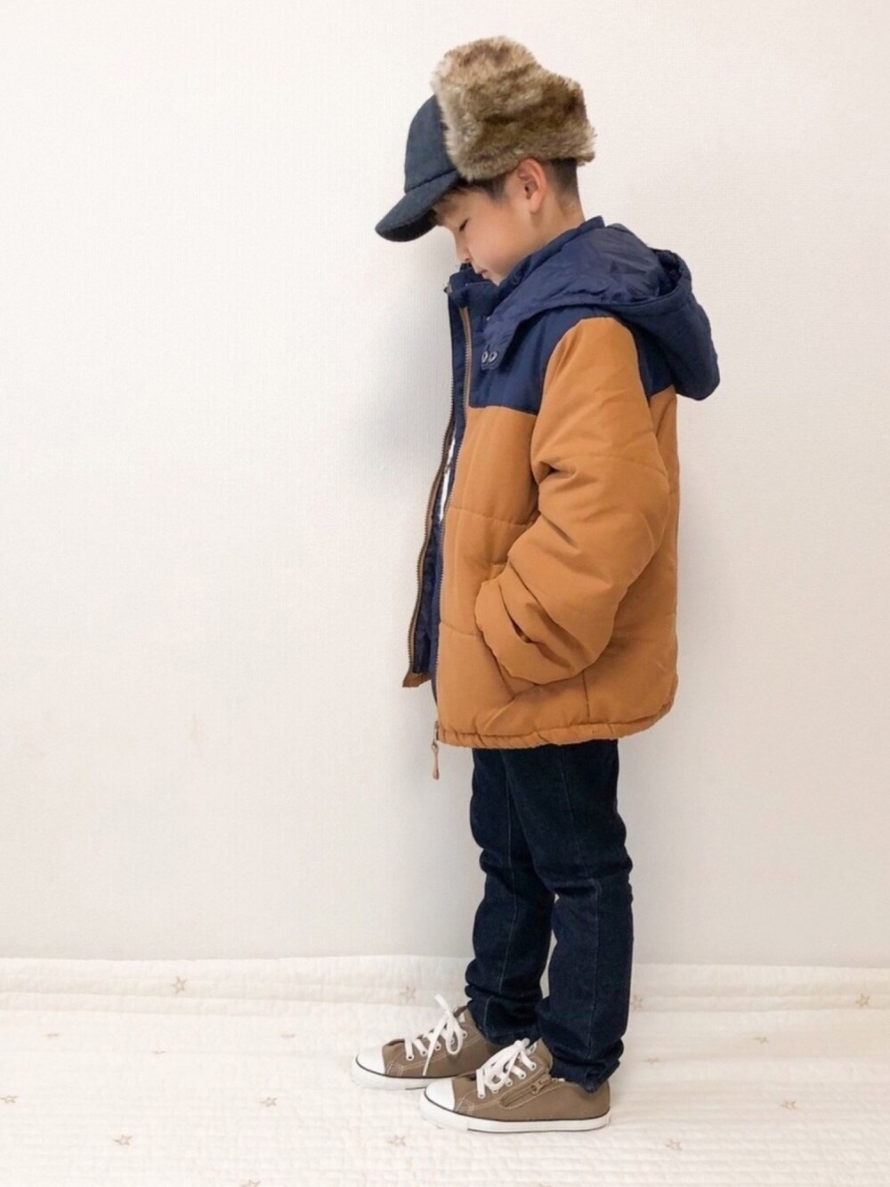 ブルー系のデニムパンツ、ブラウン系のスニーカー、ブラウン系のダウンジャケット/コートを着用したキッズの冬コーディネートの1枚目の写真