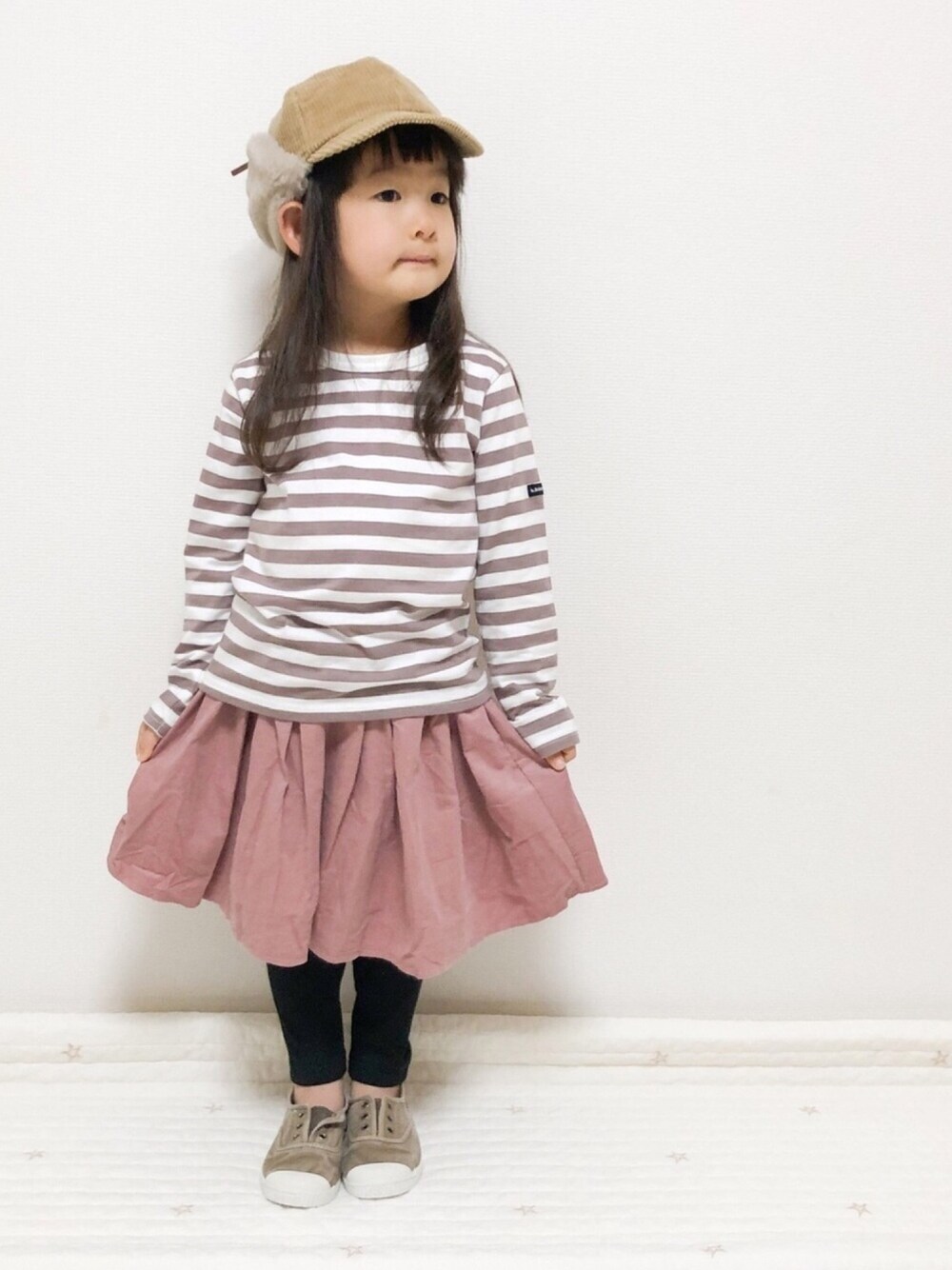 ベージュ系のTシャツ/カットソー、ピンク系のスカートを着用したキッズの冬コーディネートの1枚目の写真