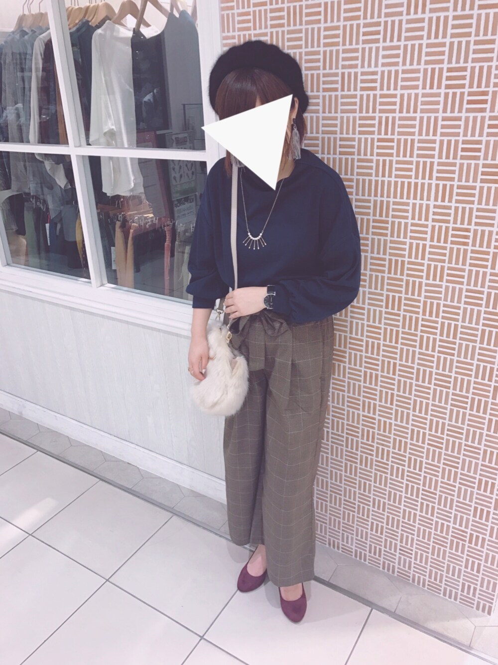 ブラウン系のパンツ、ベージュ系のハンドバッグ、ブルー系のTシャツ/カットソーを着用したレディースの秋コーディネートの1枚目の写真