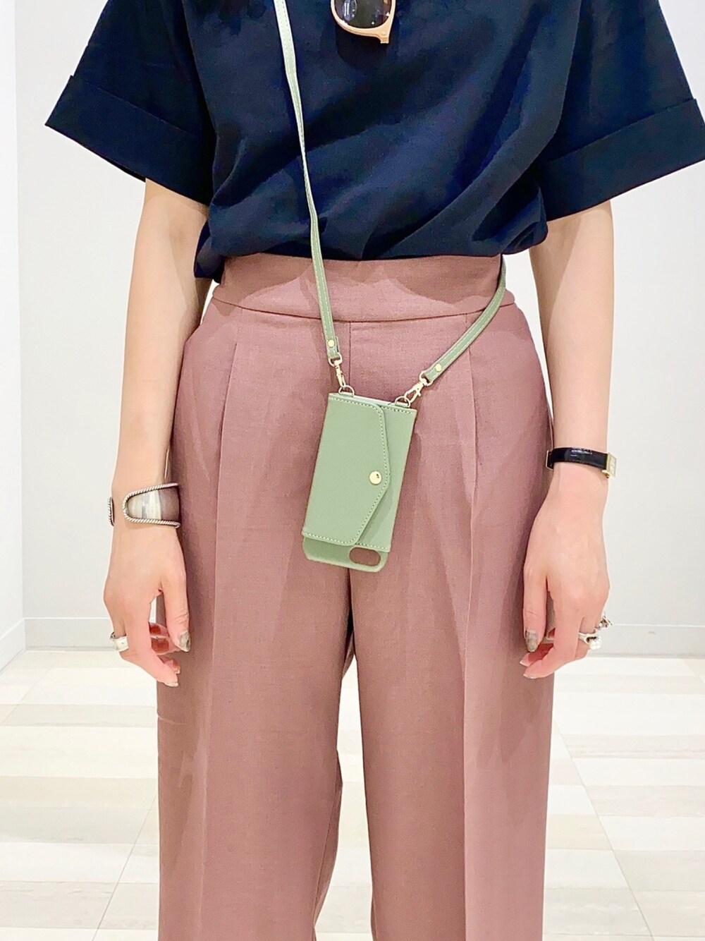 パープル系のその他パンツ、ブラック系のTシャツ/カットソー、グリーン系のスマホケース/カバーを着用したレディースの夏コーディネートの1枚目の写真