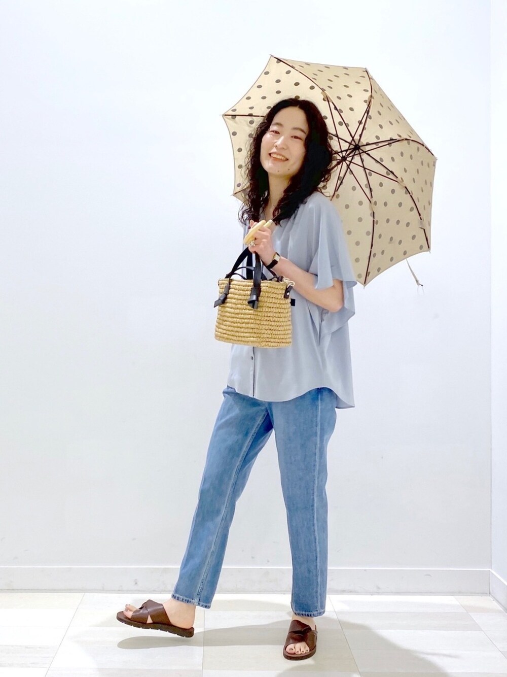 ベージュ系のショルダーバッグ、ブルー系のその他パンツ、ブラウン系のサンダルを着用したレディースの春コーディネートの1枚目の写真