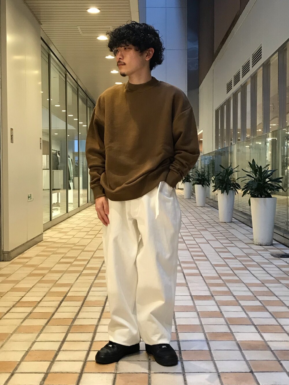 ブラウン系のスウェット、ホワイト系のパンツを着用したメンズの冬コーディネートの1枚目の写真