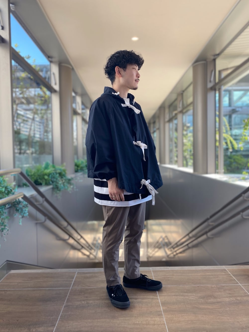 ブラック系のジャケット/アウター、その他のTシャツ/カットソー、ベージュ系のパンツを着用したメンズの春コーディネートの1枚目の写真