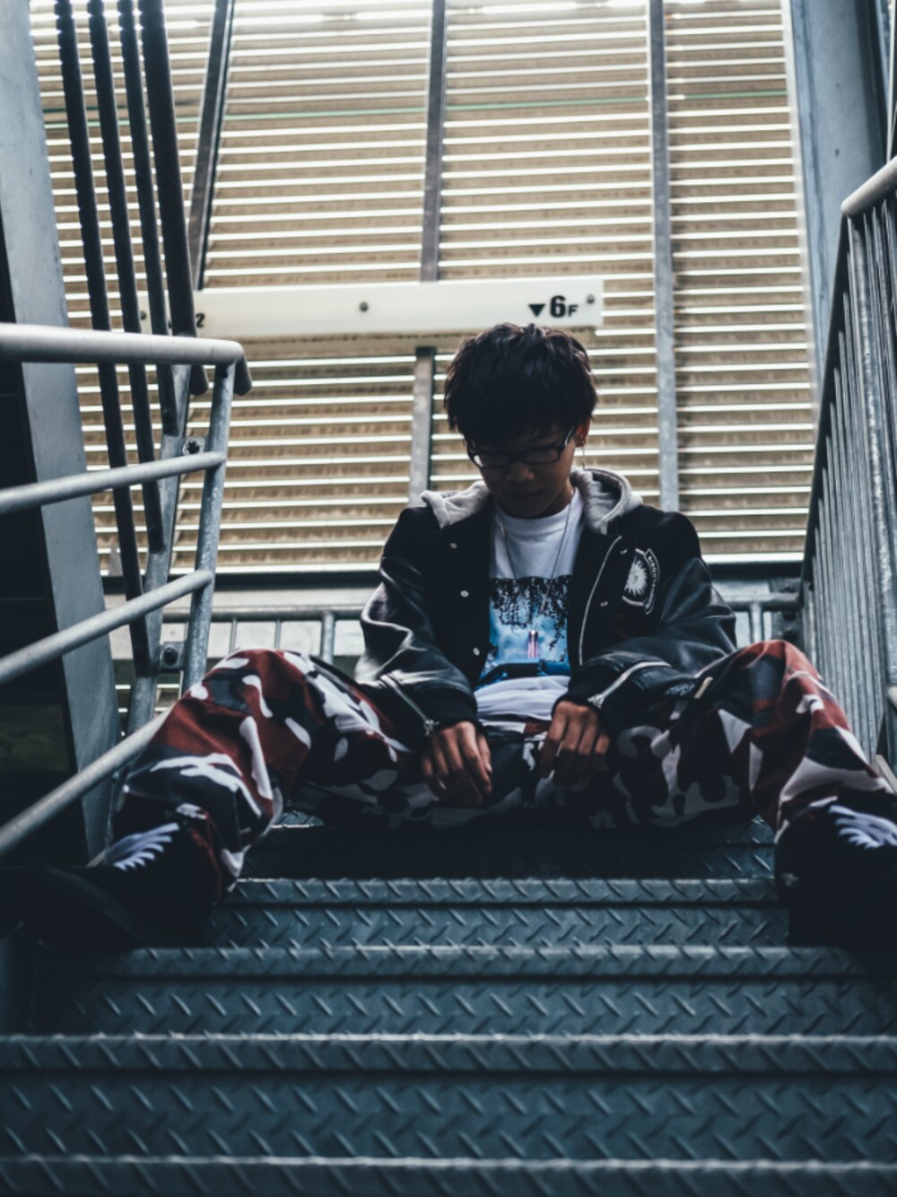 レッド系のカーゴパンツ、ホワイト系のTシャツ/カットソー、グレー系のスタジャンを着用したメンズの春コーディネートの1枚目の写真