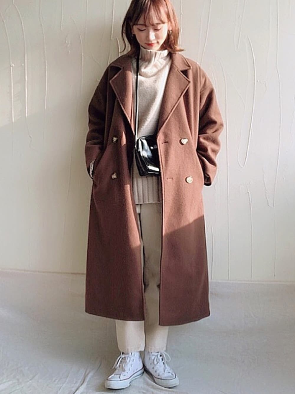 ベージュ系のニット/セーター、ベージュ系のその他パンツ、ブラウン系のチェスターコートを着用したレディースの冬コーディネートの1枚目の写真