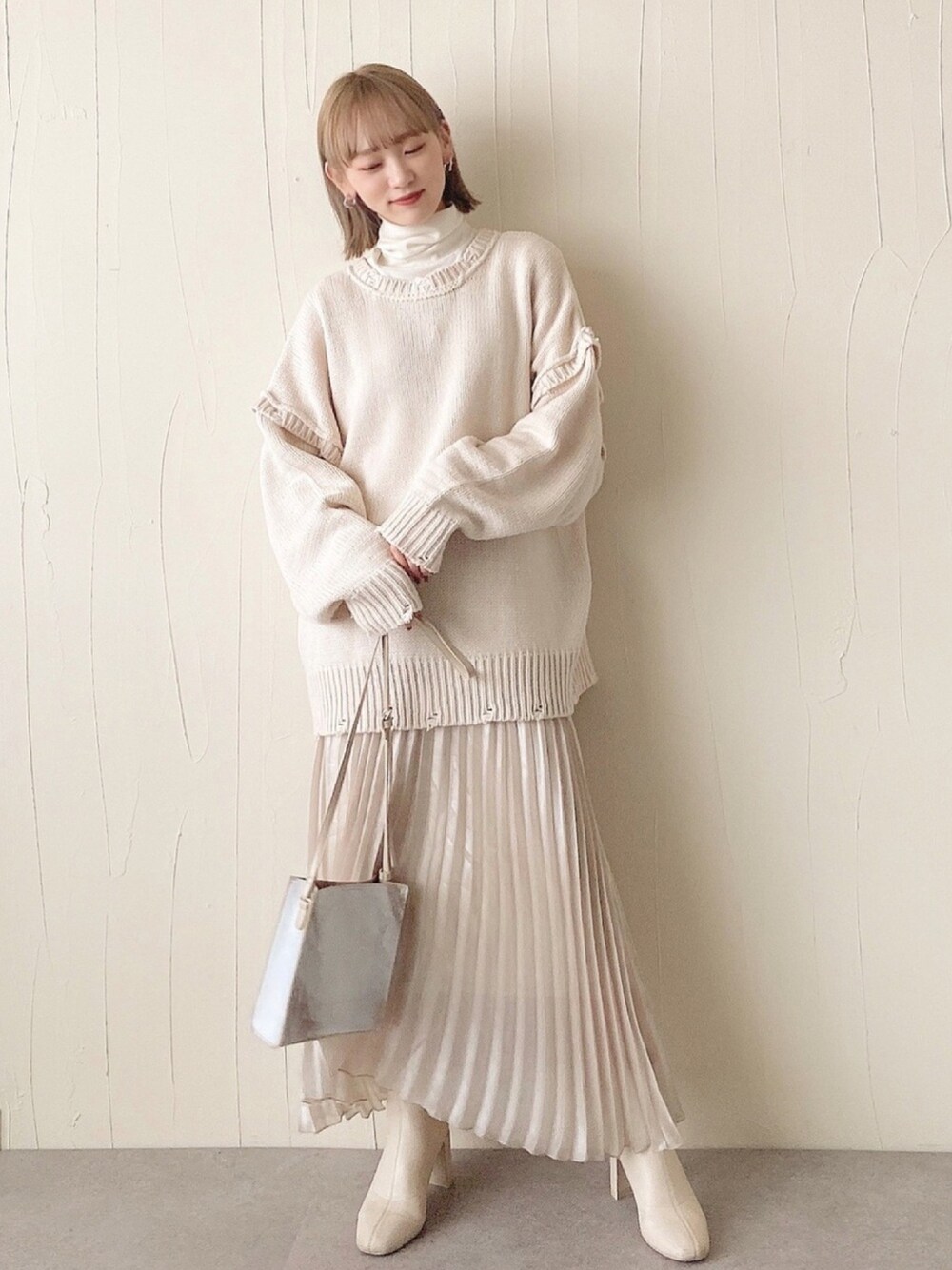 ホワイト系のニット/セーター、ホワイト系のニット/セーター、ベージュ系のスカートを着用したレディースの冬コーディネートの1枚目の写真