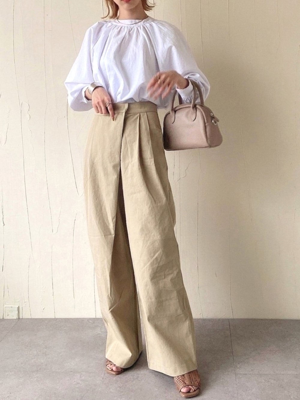 ベージュ系のその他パンツ、ホワイト系のシャツ/ブラウス、ベージュ系のボストンバッグを着用したレディースの春コーディネートの1枚目の写真
