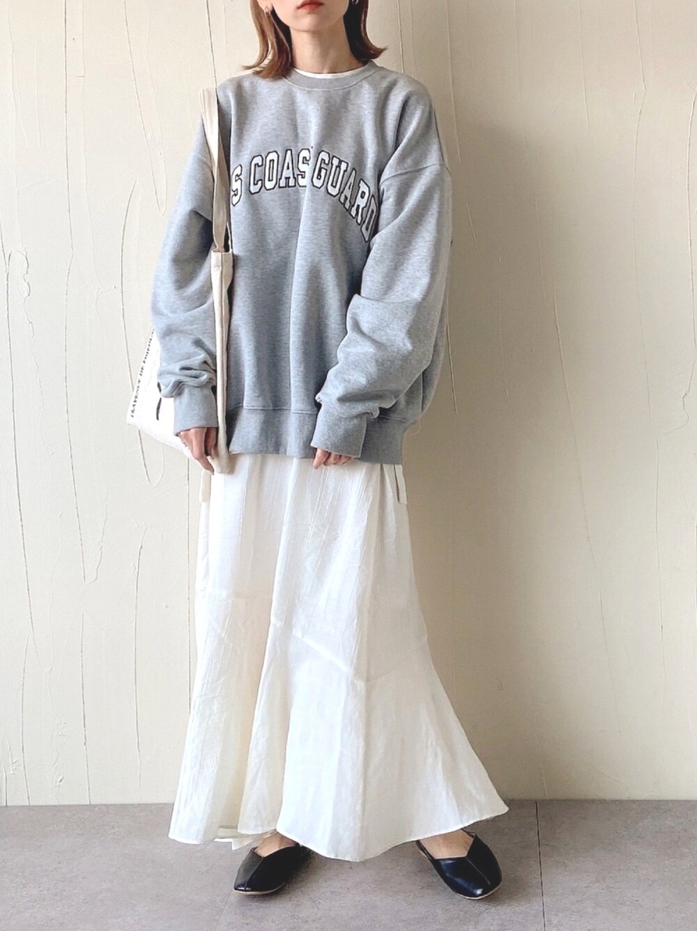グレー系のスウェット、ホワイト系のスカート、ホワイト系のTシャツ/カットソーを着用したレディースの春コーディネートの1枚目の写真