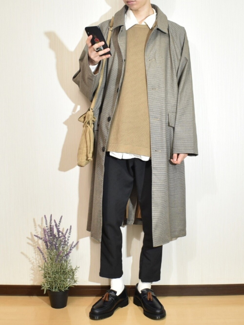 ブラック系のスラックス、ベージュ系のニット/セーター、ベージュ系のショルダーバッグを着用したメンズの秋コーディネートの1枚目の写真