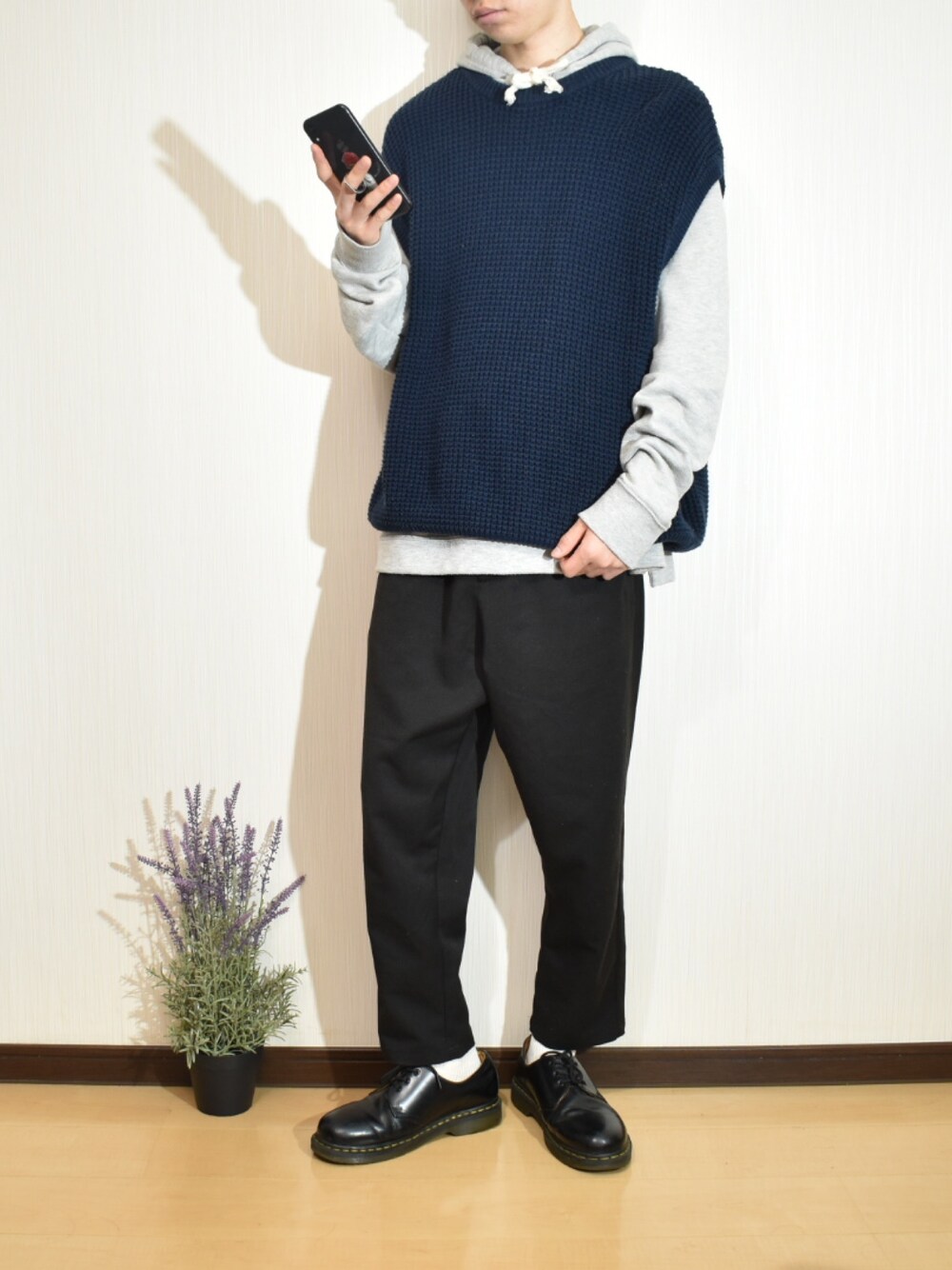 グレー系のパーカー、ブルー系のベスト、ブラック系のその他パンツを着用したメンズの秋コーディネートの1枚目の写真