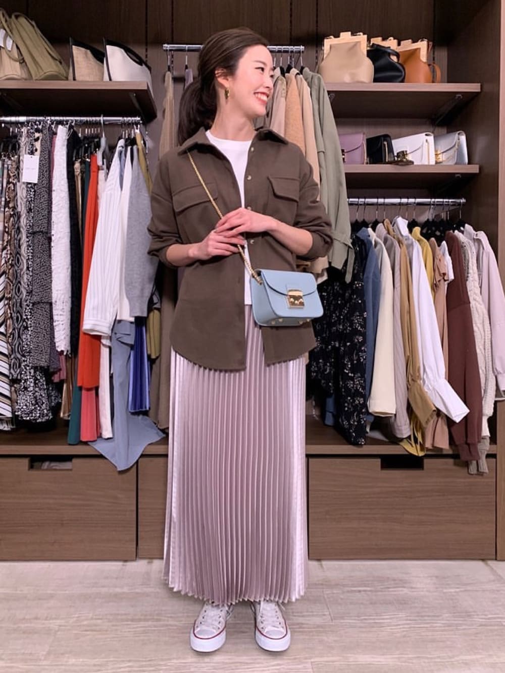 グレー系のスカート、グリーン系のライダースジャケット、オレンジ系のセットアップを着用したレディースの春コーディネートの1枚目の写真