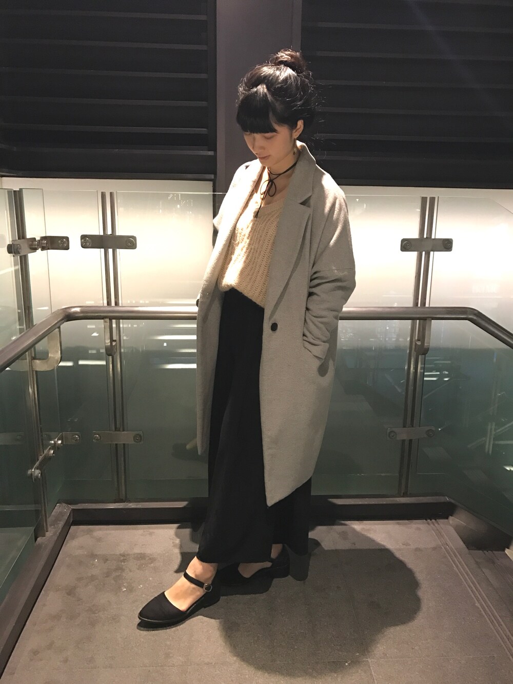 ブラック系のパンツ、ピンク系のニット/セーター、グレー系のチェスターコートを着用したレディースの冬コーディネートの1枚目の写真