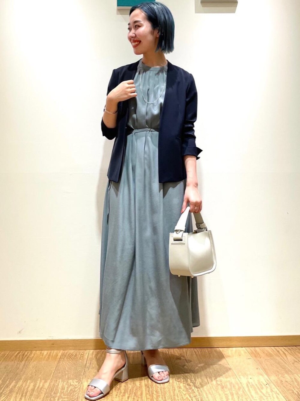 シルバー系のサンダル、グリーン系のワンピース、ブルー系のノーカラージャケットを着用したレディースの夏コーディネートの1枚目の写真