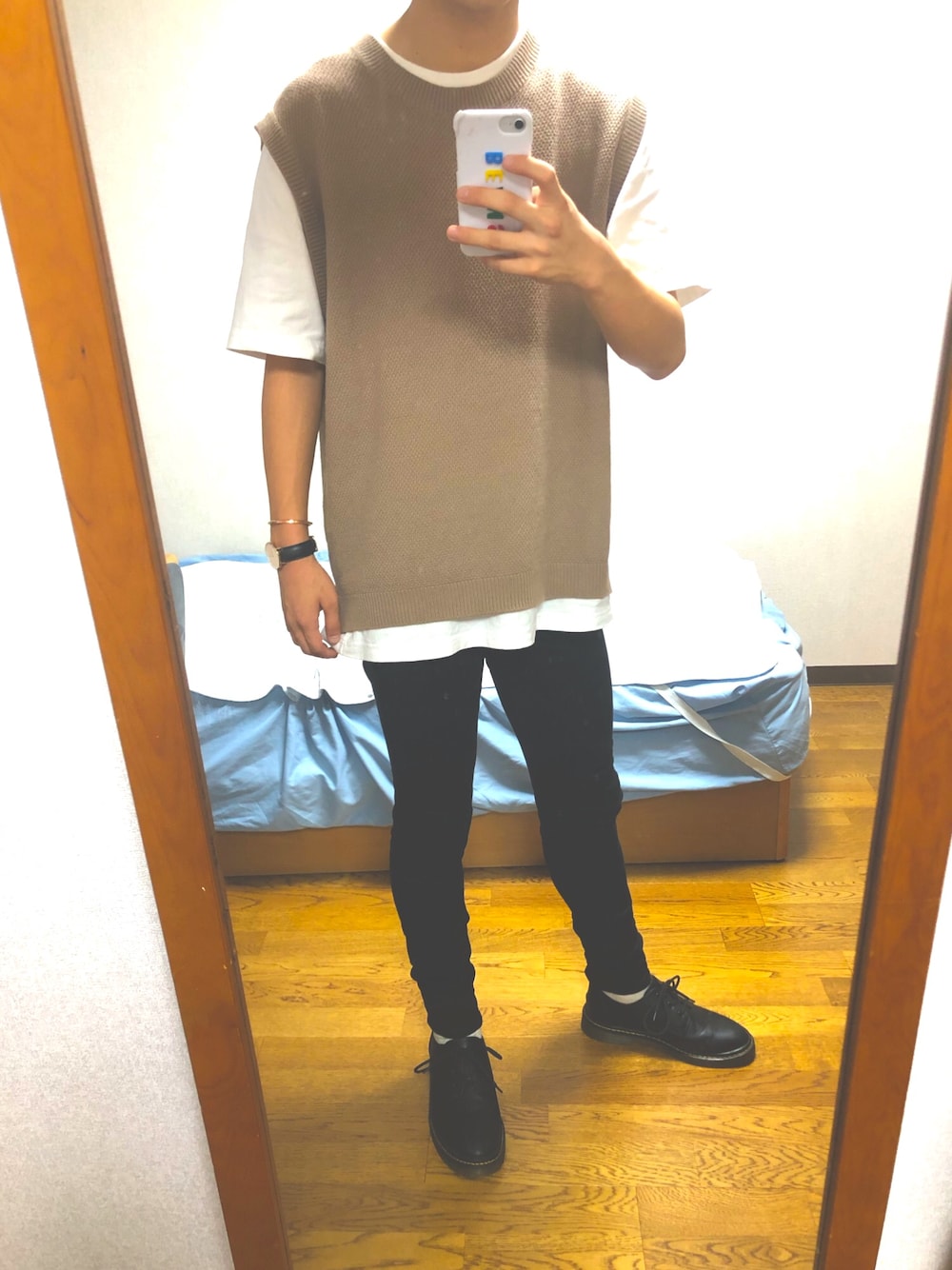 ベージュ系のベスト、ホワイト系のTシャツ/カットソー、ブラック系のデニムパンツを着用したメンズの秋コーディネートの1枚目の写真