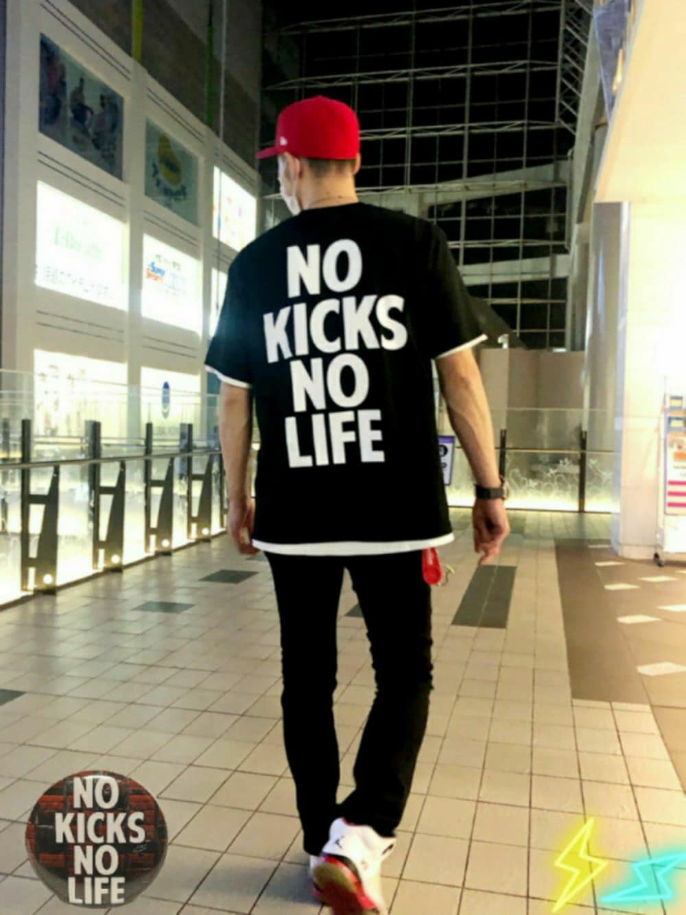 ブラック系のTシャツ/カットソー、ホワイト系のスニーカー、レッド系のキャップを着用したメンズの秋コーディネートの1枚目の写真