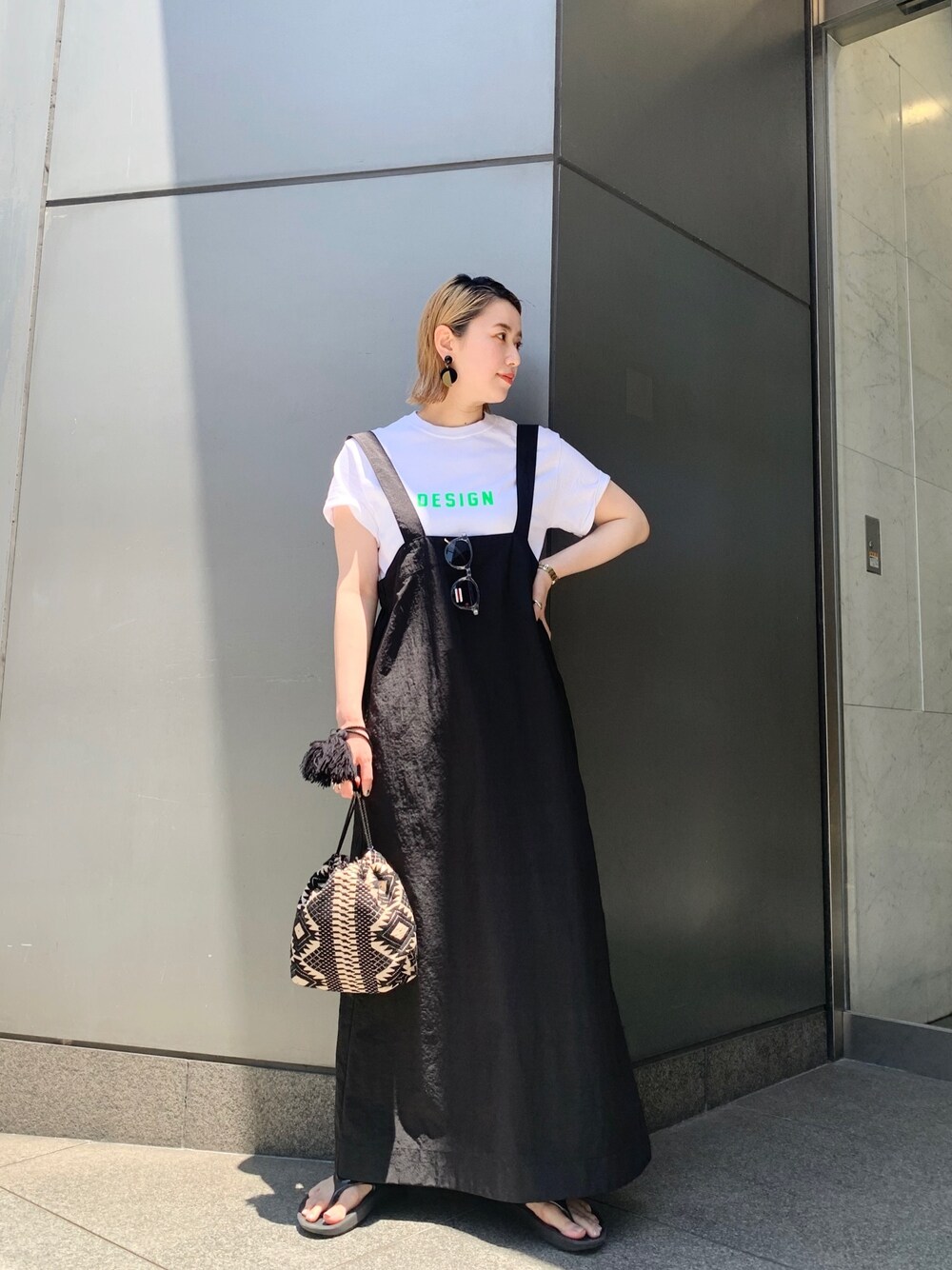 ホワイト系のTシャツ/カットソー、ブラック系のワンピース、ブラック系のハンドバッグを着用したレディースの夏コーディネートの1枚目の写真