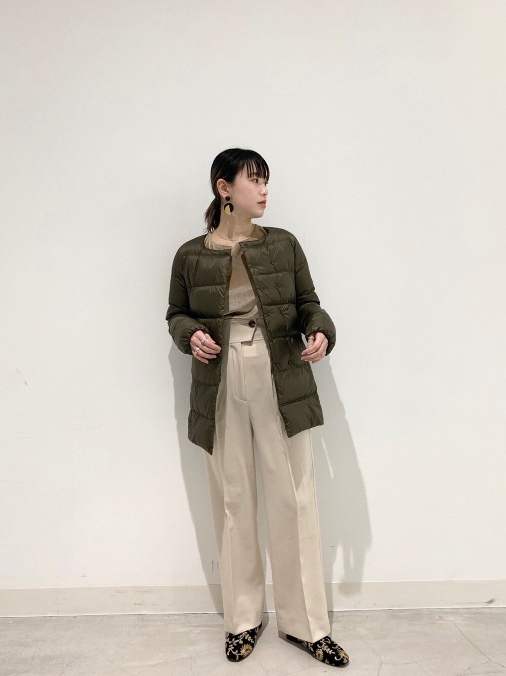 グリーン系のダウンジャケット/コート、ベージュ系のTシャツ/カットソー、ホワイト系のその他パンツを着用したレディースの冬コーディネートの1枚目の写真
