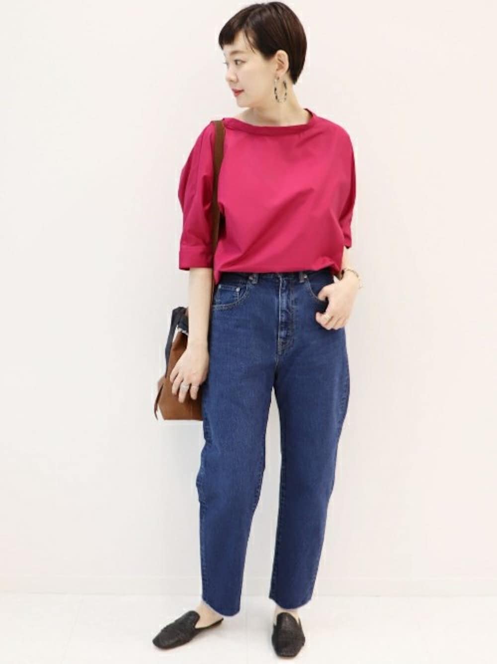 ピンク系のシャツ/ブラウス、ブルー系のデニムパンツを着用したレディースの春コーディネートの1枚目の写真