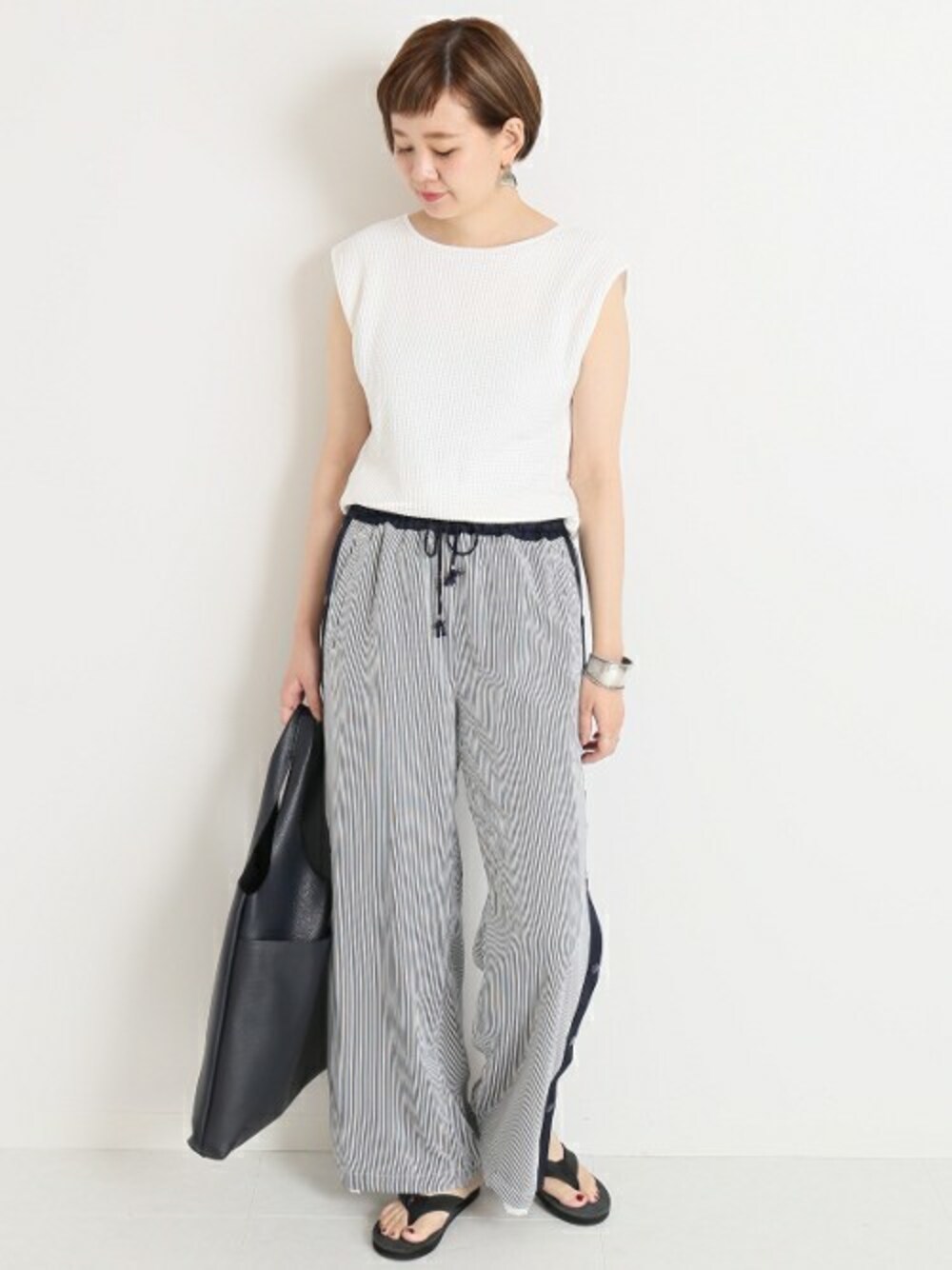 ブラック系のビーチサンダル、ブルー系のその他パンツを着用したレディースの春コーディネートの1枚目の写真