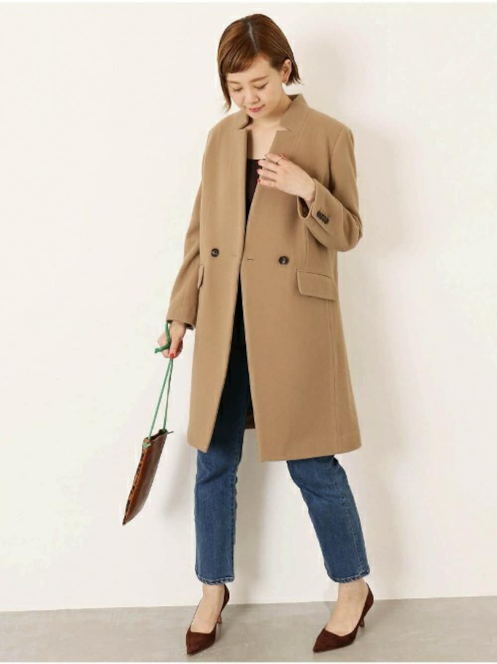 イエロー系のチェスターコートを着用したレディースの夏コーディネートの1枚目の写真