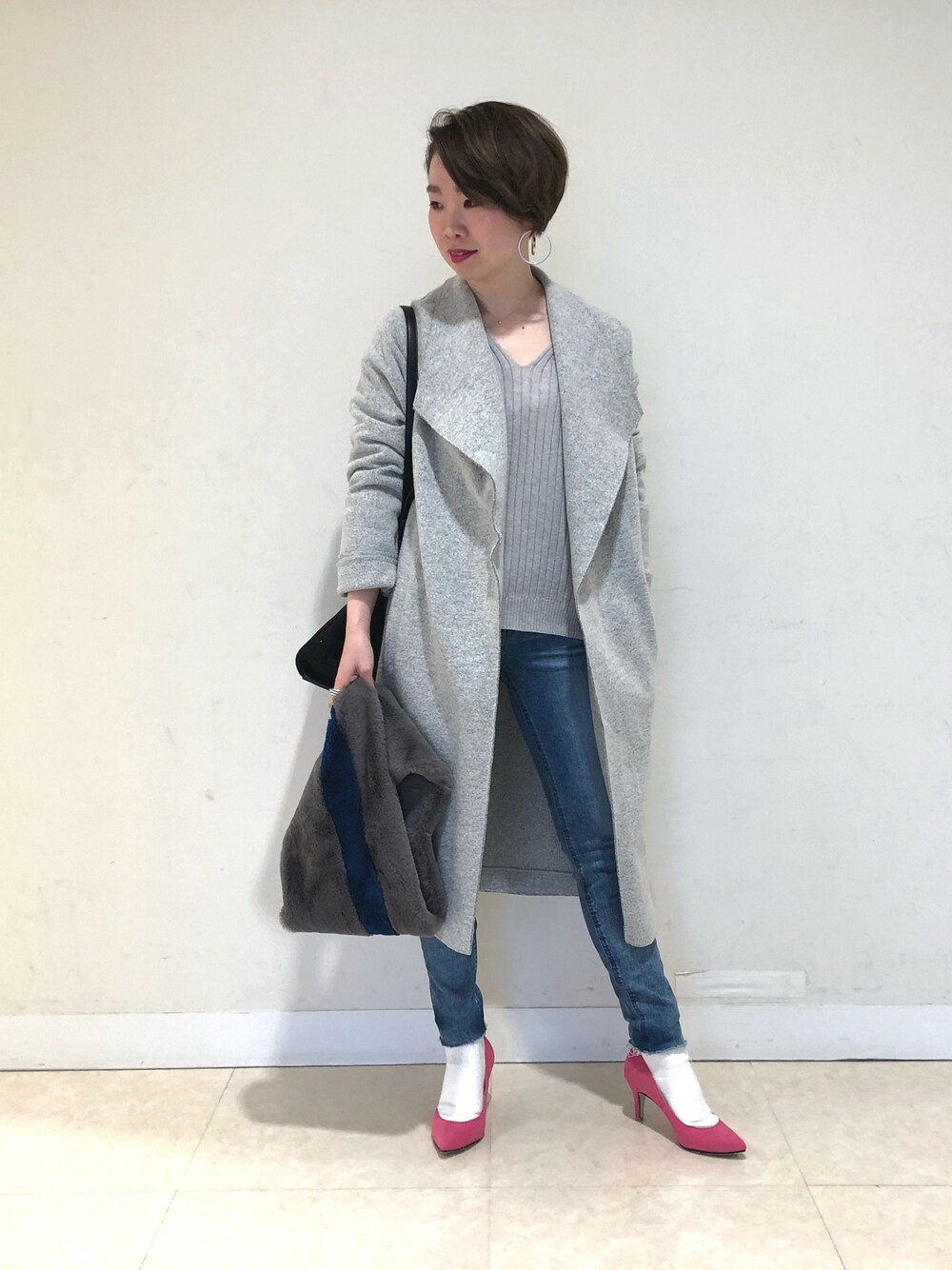 グレー系のその他アウター、グレー系のニット/セーター、ブルー系のデニムパンツを着用したレディースの冬コーディネートの1枚目の写真
