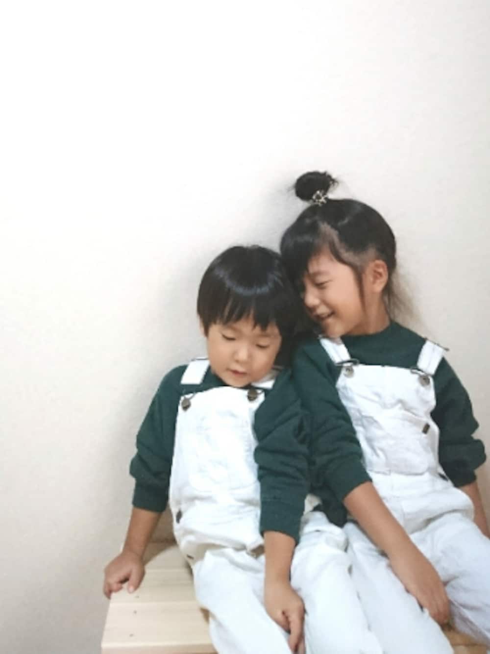 グリーン系のスウェット、グリーン系のスウェット、ホワイト系のサロペット/オーバーオールを着用したキッズの秋コーディネートの1枚目の写真