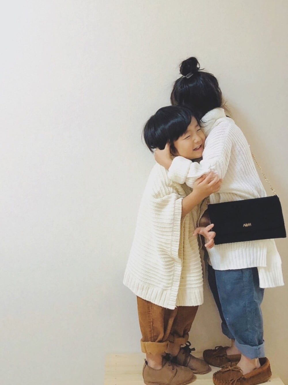 ホワイト系のニット/セーター、ホワイト系のポンチョ、ブルー系のその他パンツを着用したキッズの冬コーディネートの1枚目の写真