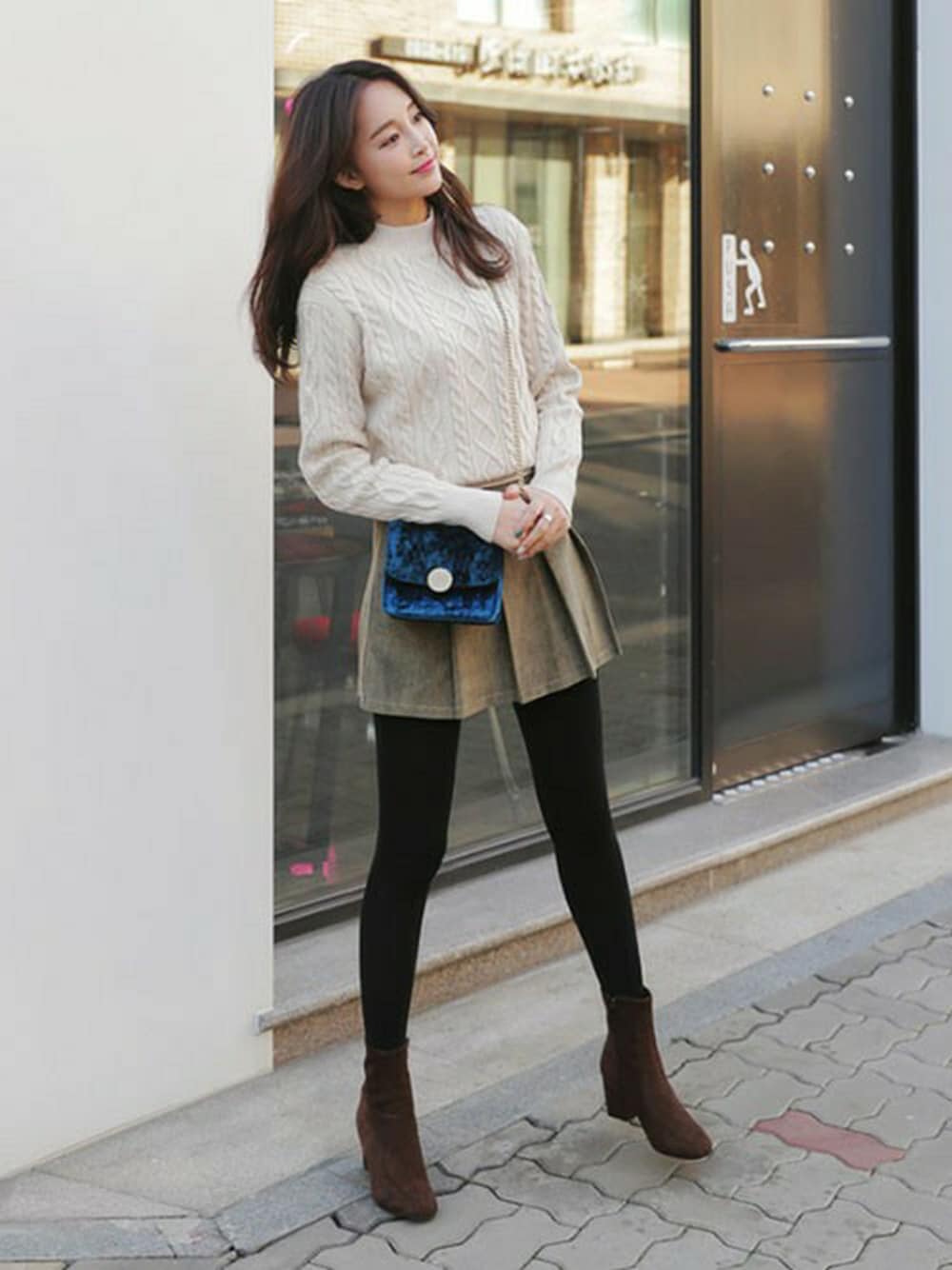 ホワイト系のニット/セーター、グリーン系のスカートを着用したレディースの冬コーディネートの1枚目の写真