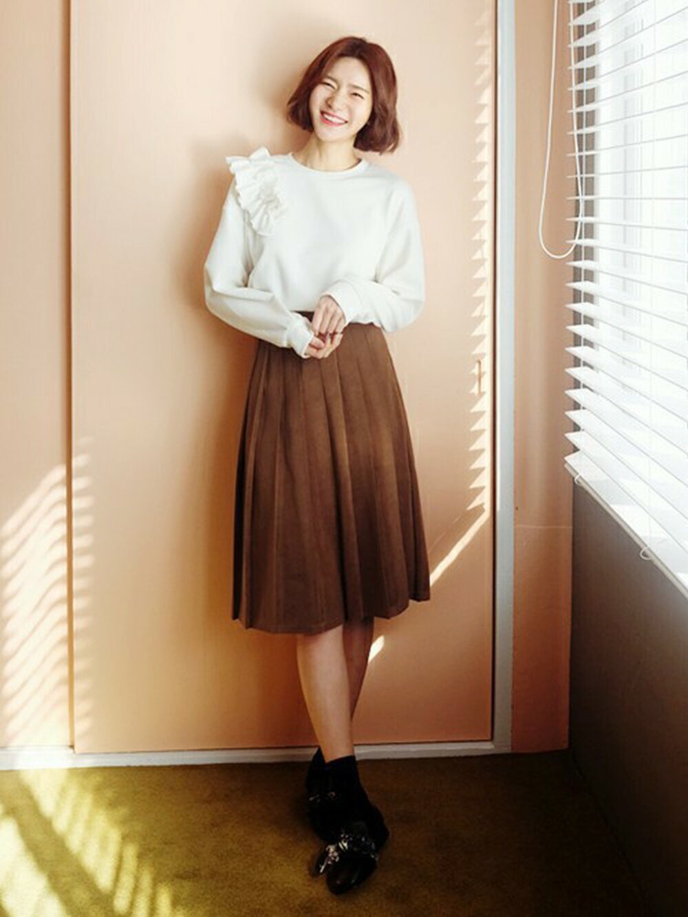 ブラウン系のスカート、ホワイト系のスウェット、ブラック系のその他シューズを着用したレディースの冬コーディネートの1枚目の写真