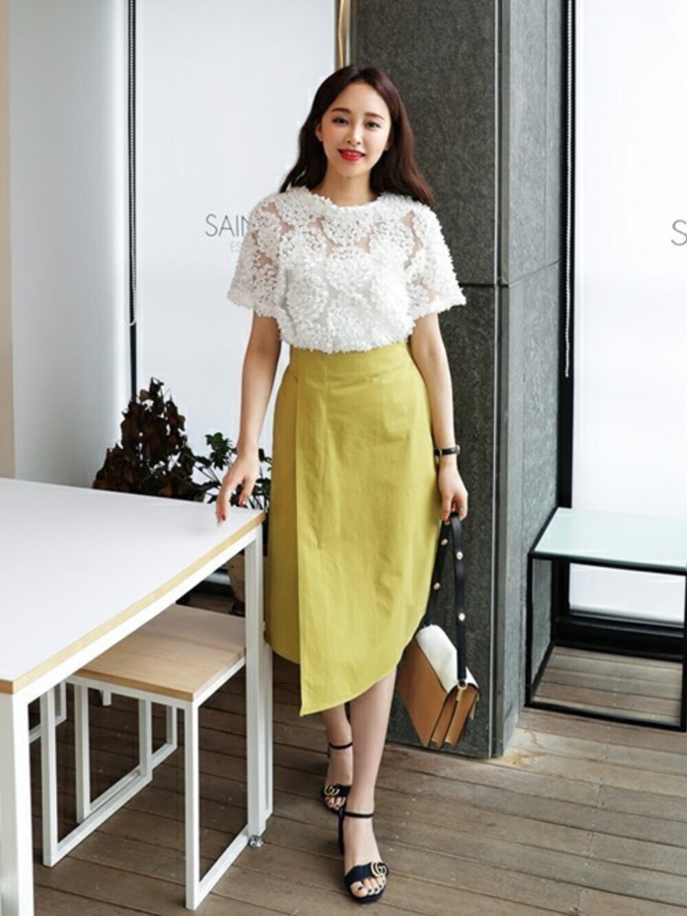 ホワイト系のシャツ/ブラウス、イエロー系のスカートを着用したレディースの春コーディネートの1枚目の写真