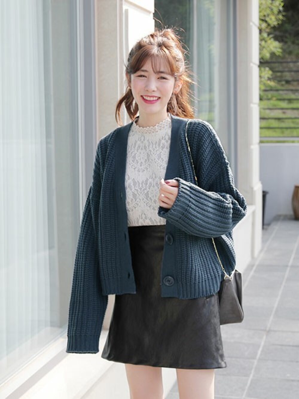 ブルー系のカーディガン/ボレロ、グレー系のシャツ/ブラウス、ブラック系のスカートを着用したレディースの秋コーディネートの1枚目の写真