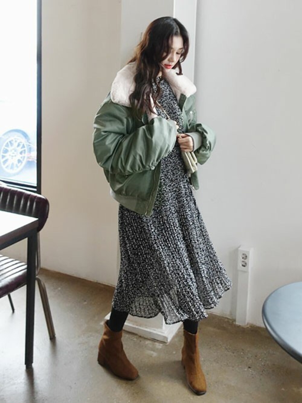 グリーン系のブルゾン、ブラック系のワンピースを着用したレディースの冬コーディネートの1枚目の写真