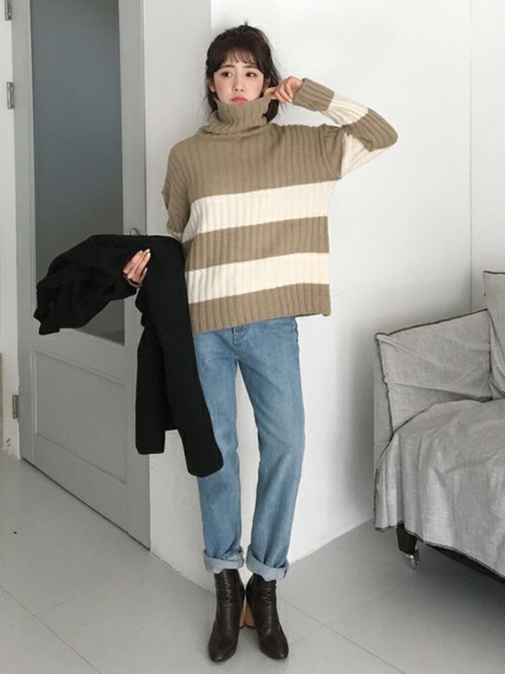 ベージュ系のニット/セーター、ブルー系のデニムパンツを着用したレディースの冬コーディネートの1枚目の写真