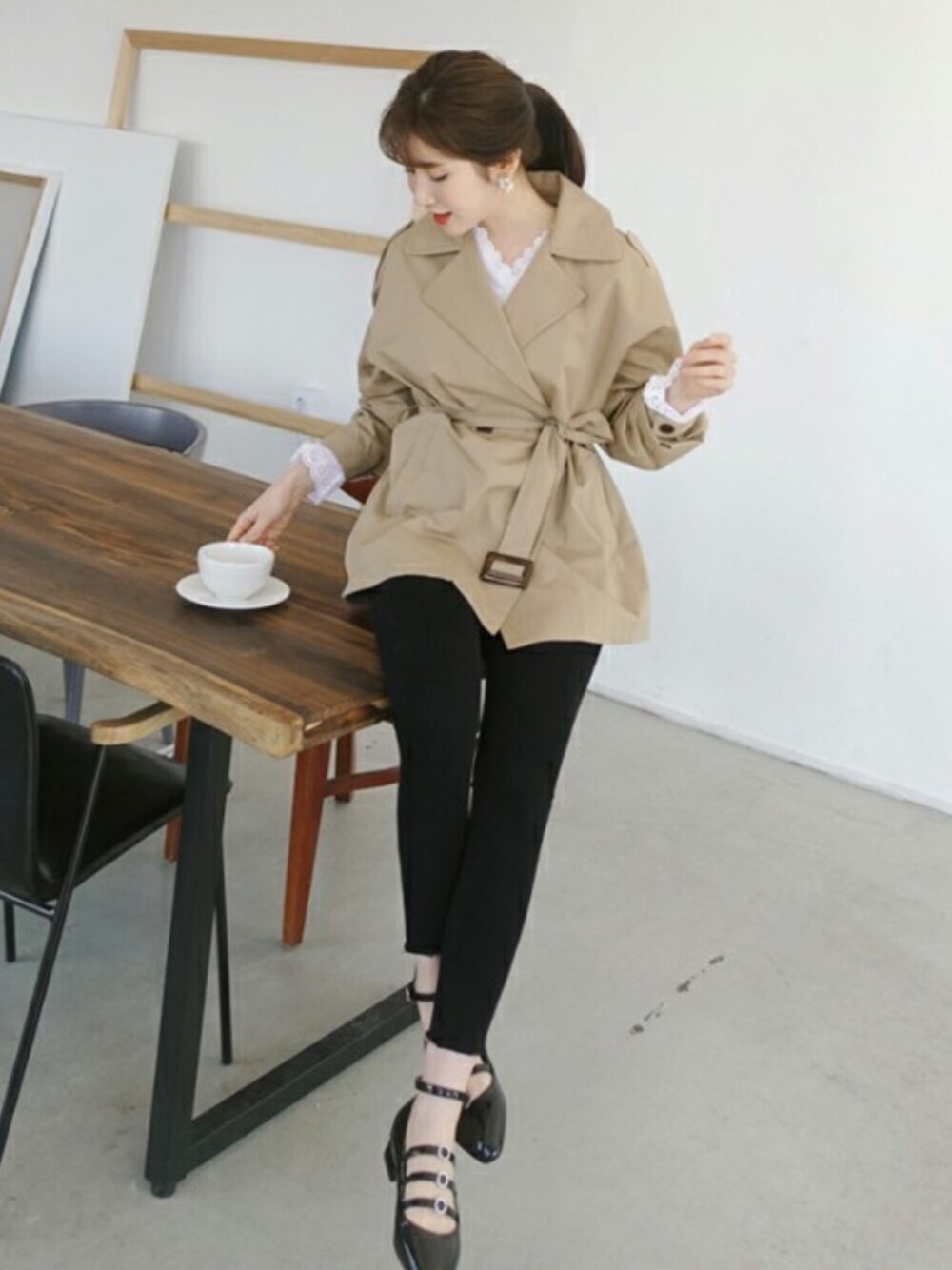 ベージュ系のトレンチコートを着用したレディースの冬コーディネートの1枚目の写真