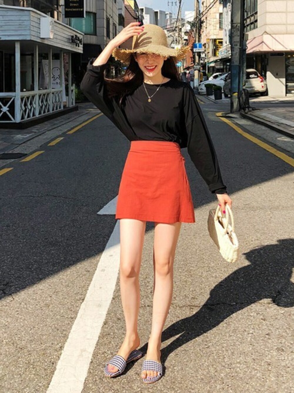 レッド系のその他パンツ、ブラック系のTシャツ/カットソー、ベージュ系のハットを着用したレディースの夏コーディネートの1枚目の写真