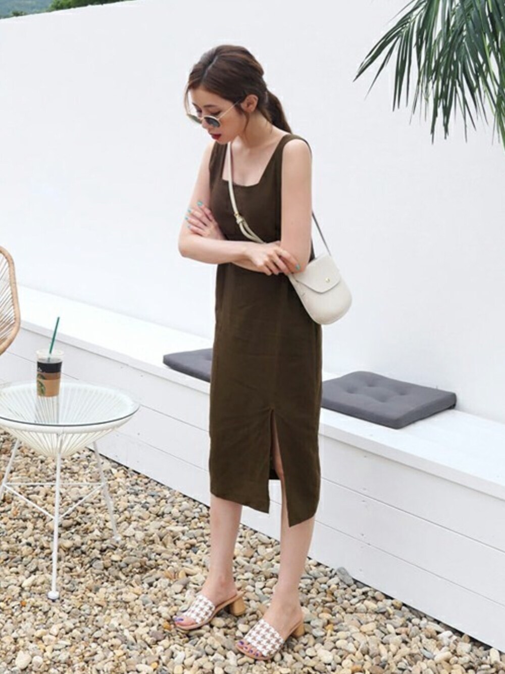 ブラウン系のワンピース、ホワイト系のショルダーバッグ、ベージュ系のサンダルを着用したレディースの夏コーディネートの1枚目の写真