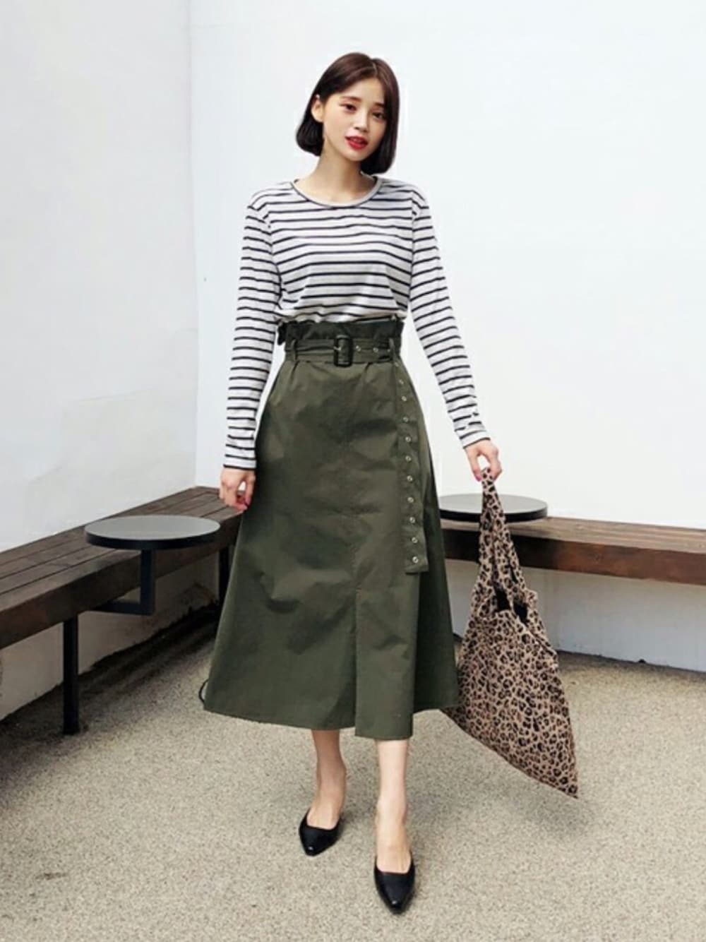 グレー系のTシャツ/カットソー、グリーン系のスカートを着用したレディースの秋コーディネートの1枚目の写真