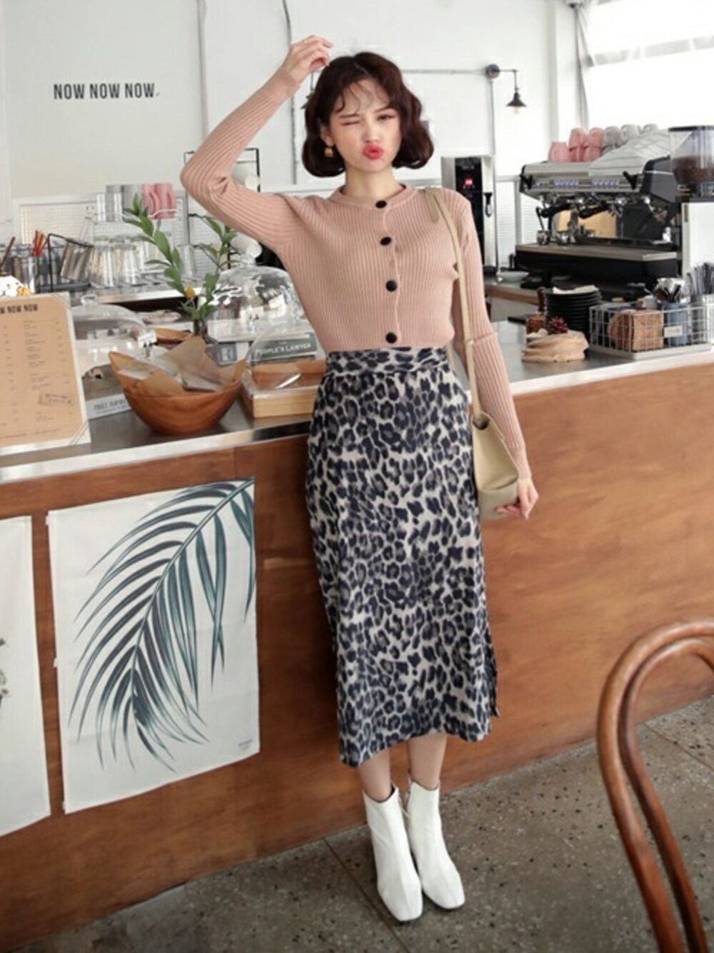 グレー系のスカート、ピンク系のカーディガン/ボレロ、ゴールド系のピアス(両耳用)を着用したレディースの秋コーディネートの1枚目の写真