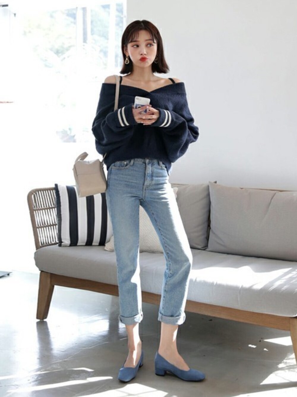 ブルー系のニット/セーター、ゴールド系のピアス（両耳用）を着用したレディースの秋コーディネートの1枚目の写真