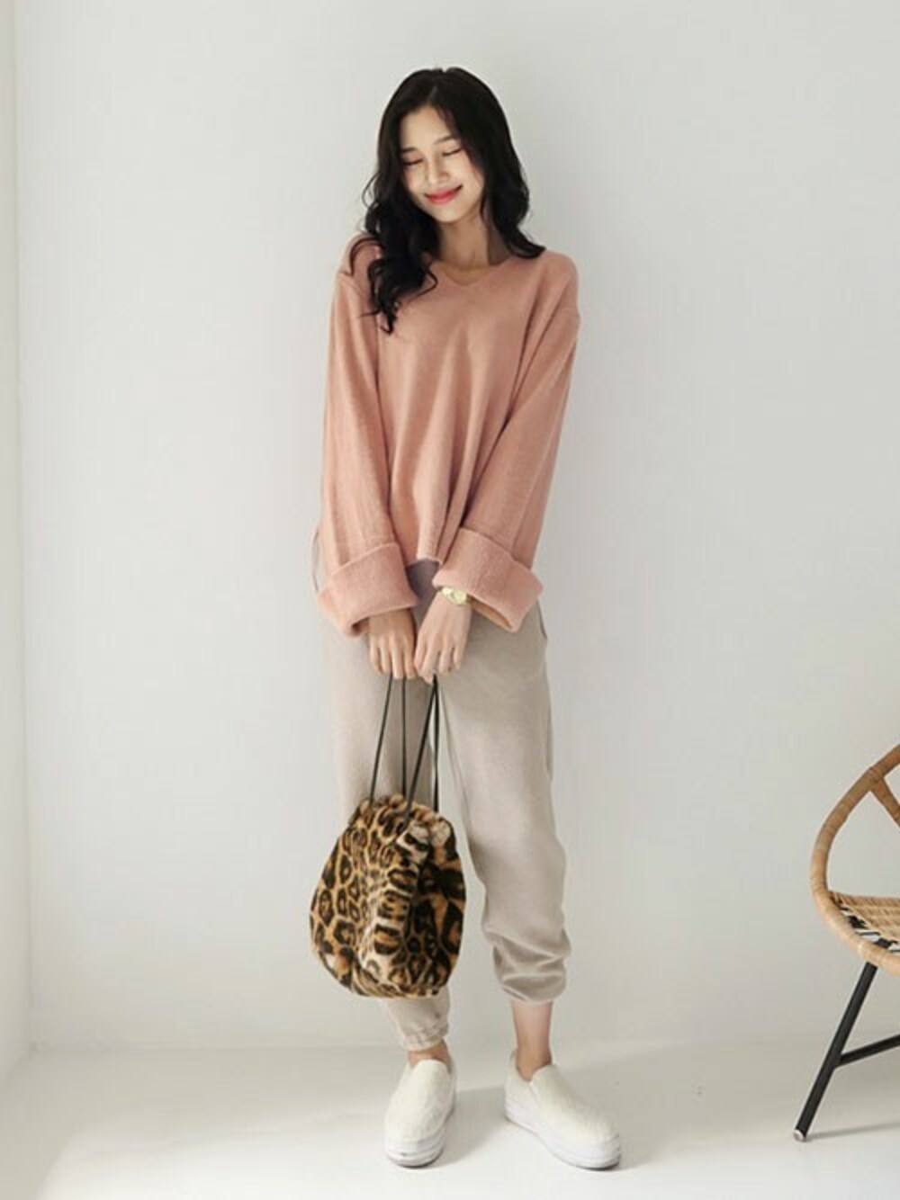 その他のハンドバッグ、ピンク系のニット/セーター、ベージュ系のその他パンツを着用したレディースの秋コーディネートの1枚目の写真