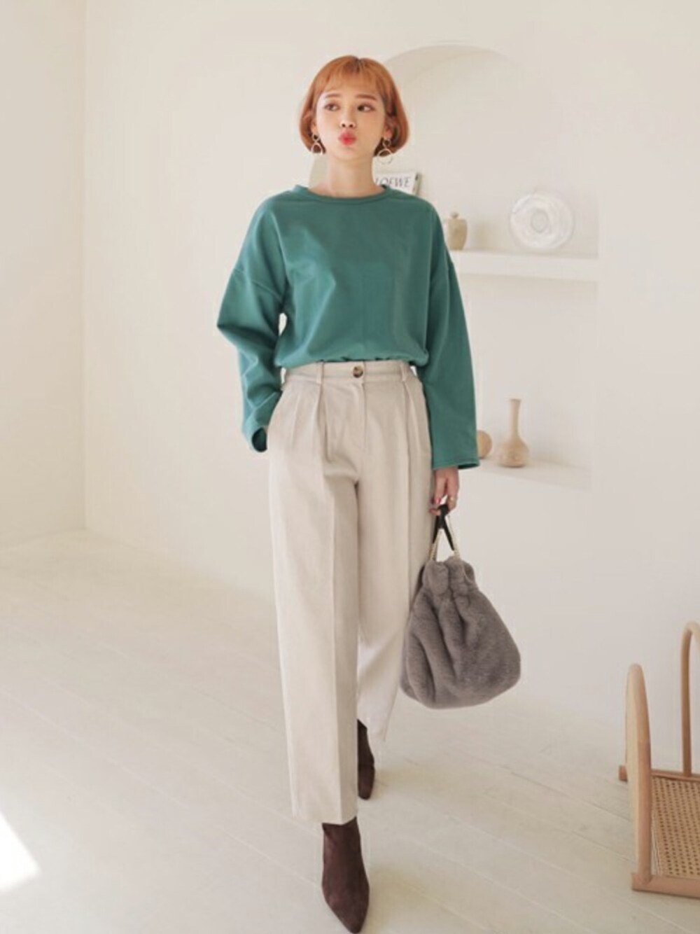 グリーン系のTシャツ/カットソー、ベージュ系のその他パンツ、グレー系のショルダーバッグを着用したレディースの冬コーディネートの1枚目の写真