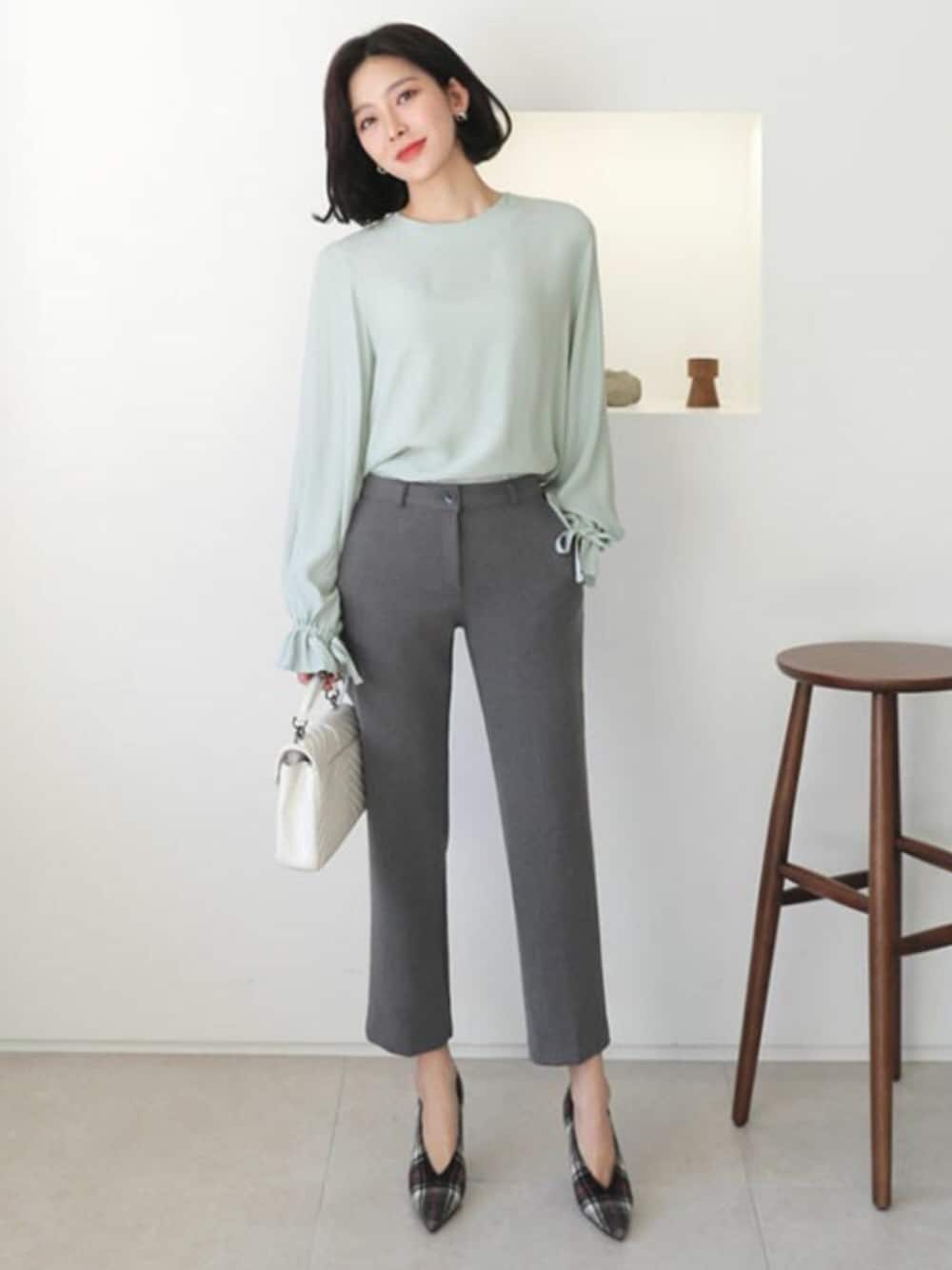 グリーン系のシャツ/ブラウス、グレー系のスラックスを着用したレディースの冬コーディネートの1枚目の写真