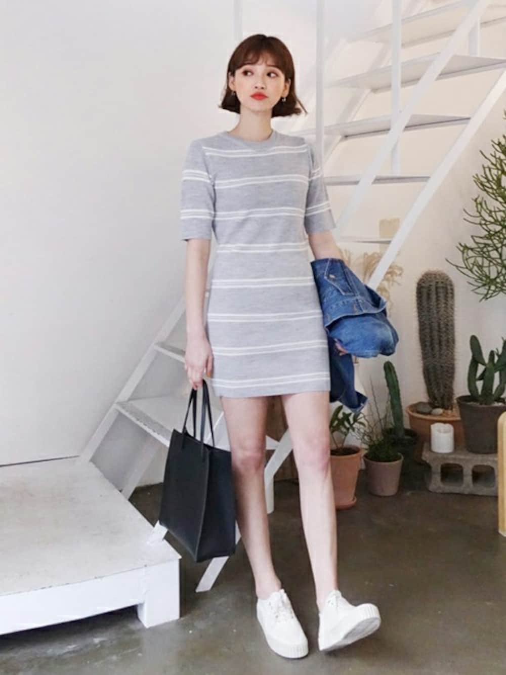 グレー系のワンピース、ブルー系のデニムジャケット、ブラック系のトートバッグを着用したレディースの春コーディネートの1枚目の写真