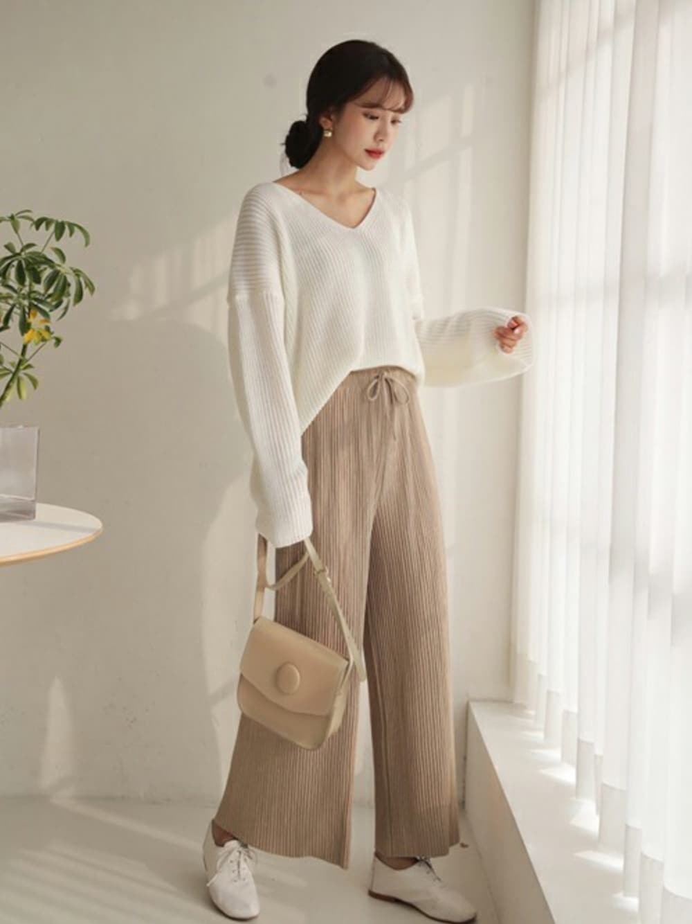 ベージュ系のその他パンツ、ホワイト系のニット/セーターを着用したレディースの春コーディネートの1枚目の写真