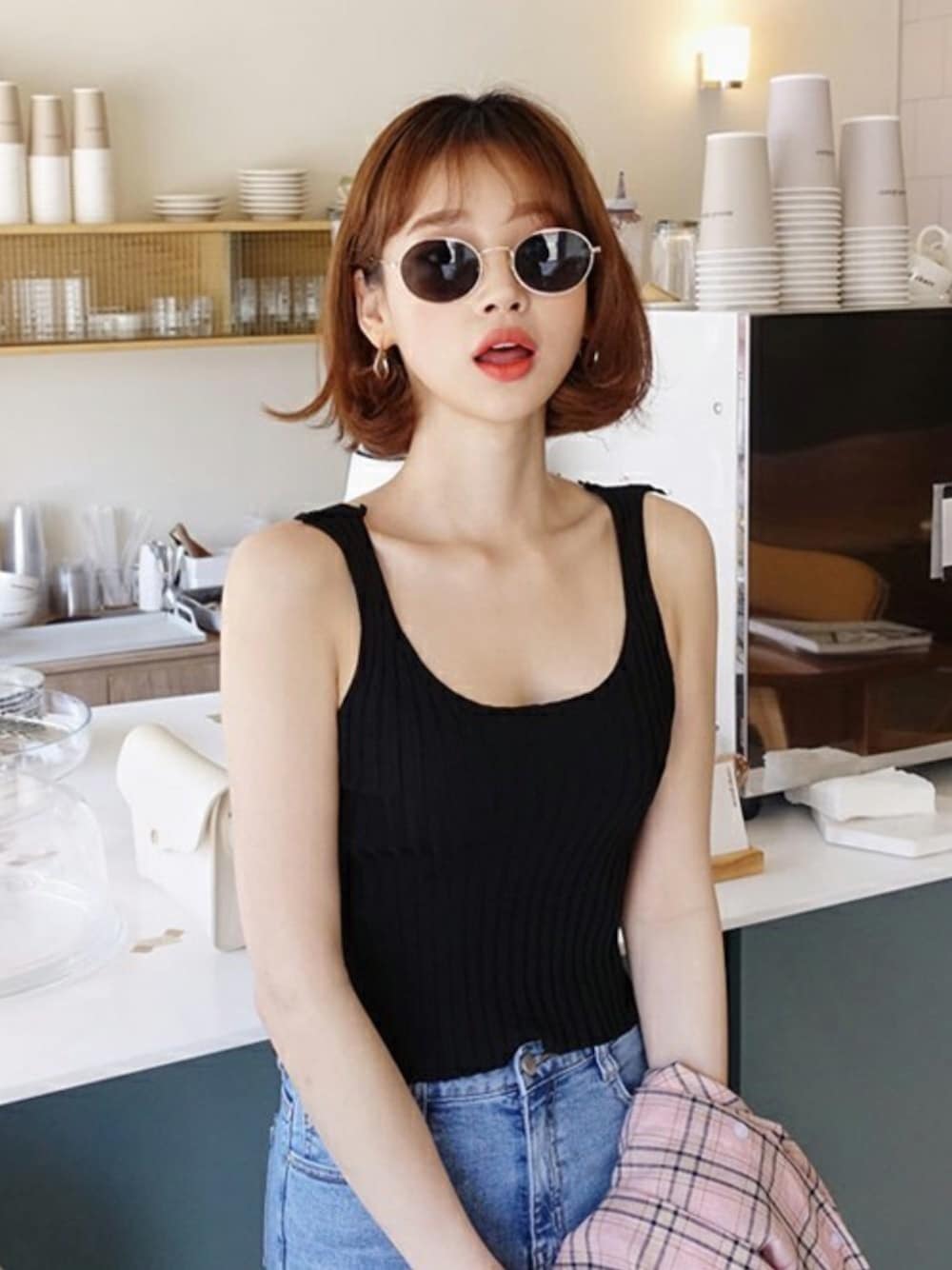 ブラック系のタンクトップ、ブルー系のデニムパンツ、ベージュ系のワンピースを着用したレディースの春コーディネートの1枚目の写真